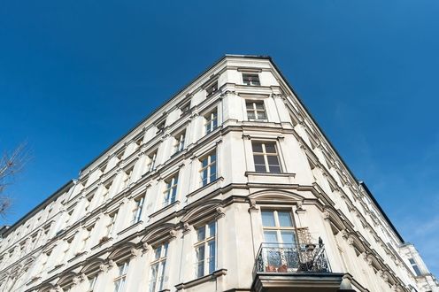 Ein weißes Altbauhaus in Berlin Pankow vor blauem Himmel im Hintergrund